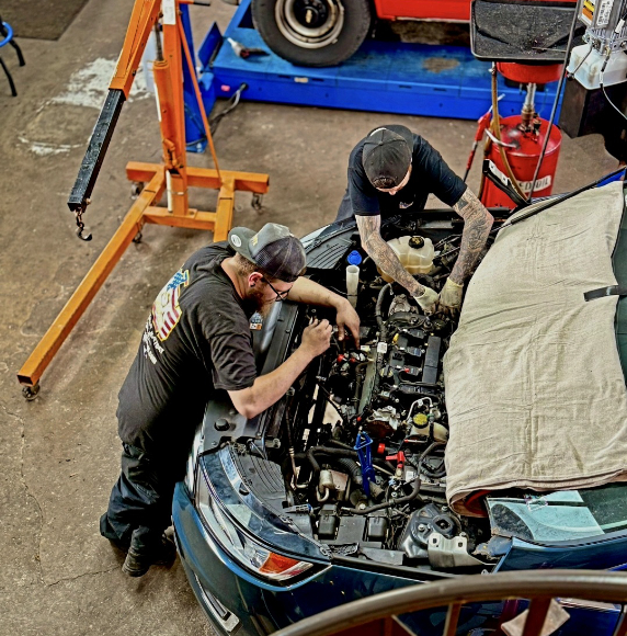 2 mechanics repairing car